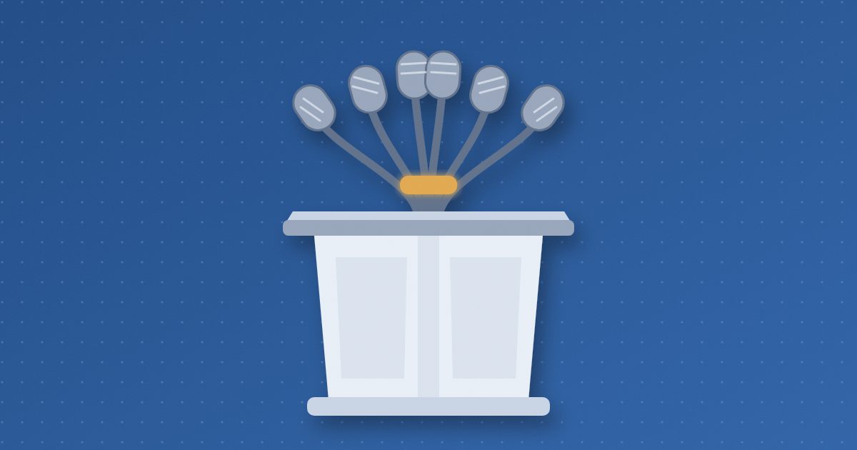 A lectern with six microphones fanning up from its top, their stalks gathered together by a single glowing amber band.