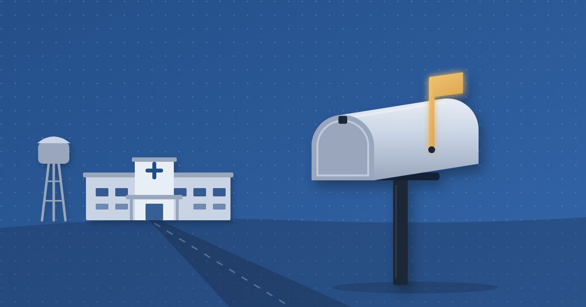 A rural mailbox with its amber flag raised stands beside a country road that leads to a small one-story hospital with a water tower.