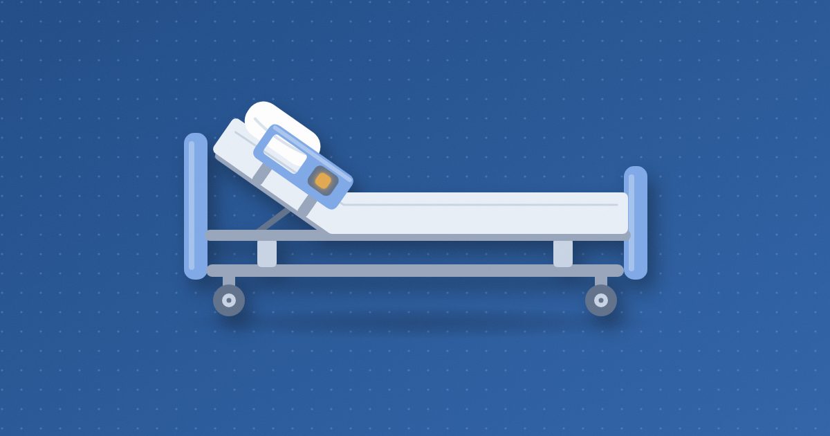 A hospital bed in side view with the head section raised, a mattress and pillow, wheels, and a side rail carrying a small amber call button.