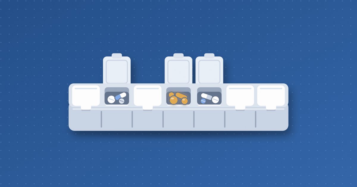 A weekly pill organizer with seven compartments in a row, three lids flipped open to show pills, the middle compartment holding amber pills.