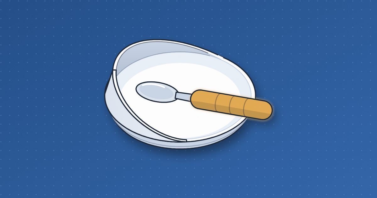 An adaptive spoon with a thick amber built-up handle resting across a white scoop plate with a high curved rim along one side.